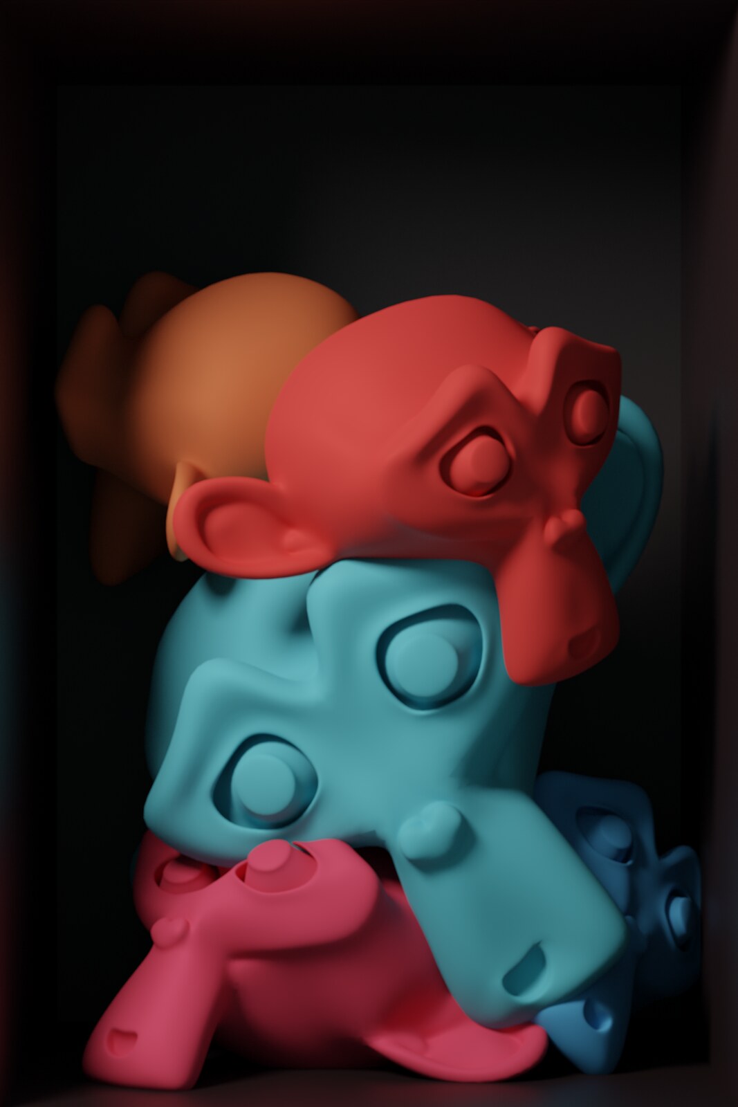 Coloured monkey-head forms slumped together inside a dark box.